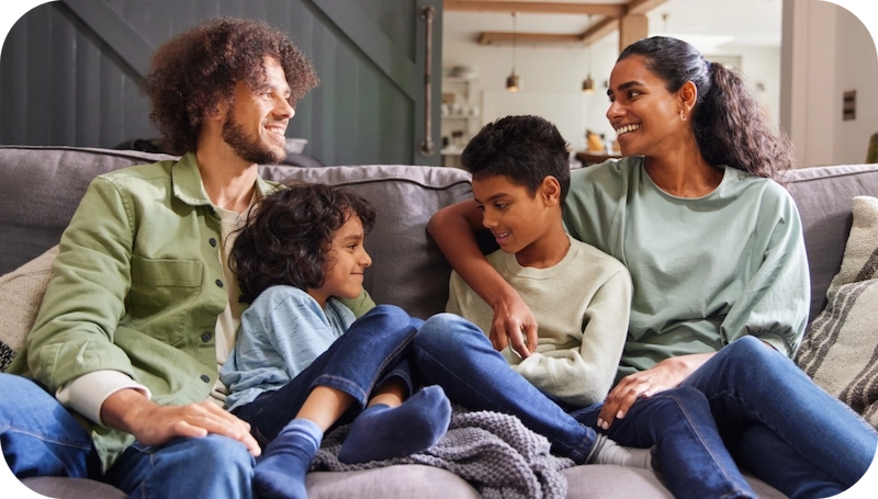 Mom, Dad and two kids playing together in the living room