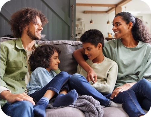 Mom, Dad and two kids playing together in the living room