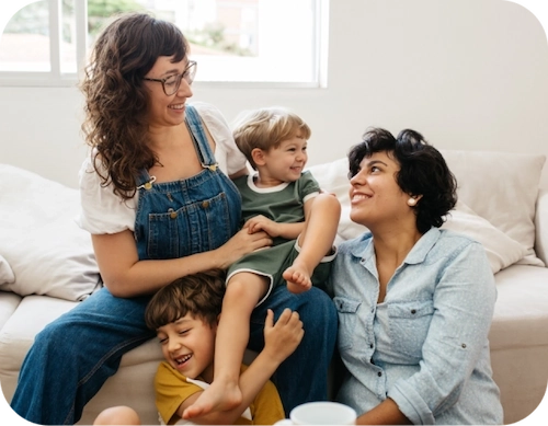 Mom, Dad and two kids playing together in the living room