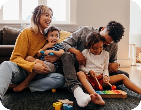 Mom, Dad and two kids playing together in the living room